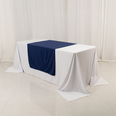 Navy table runner on a white tablecloth in a studio setting