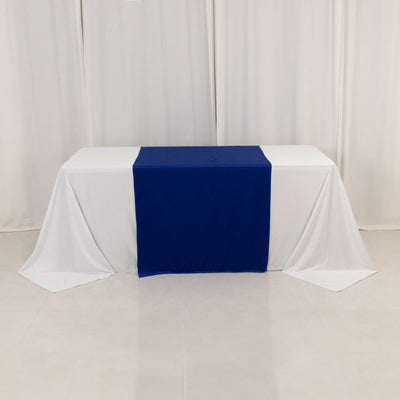 Blue table runner on a white tablecloth in a bright studio setting.