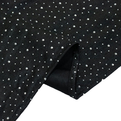 Black fabric with silver polka dots draped elegantly.