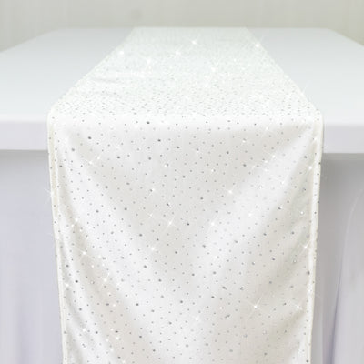 White table runner with sparkling rhinestones on a plain backdrop.
