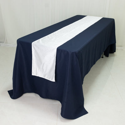 Navy tablecloth with white runner and sequins on a table