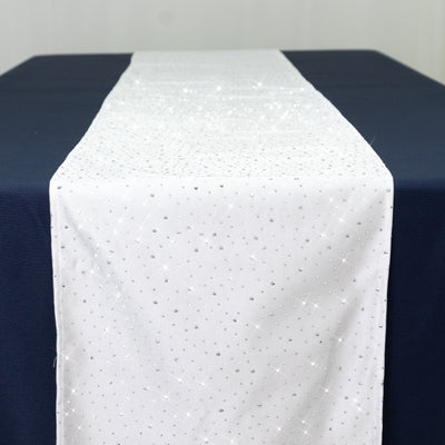 White table runner with silver sparkles on a navy blue table.