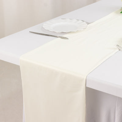 Ivory table runner on a white table setting with a plate and cutlery.