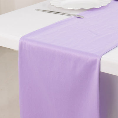 Purple satin table runner on a white table setting.