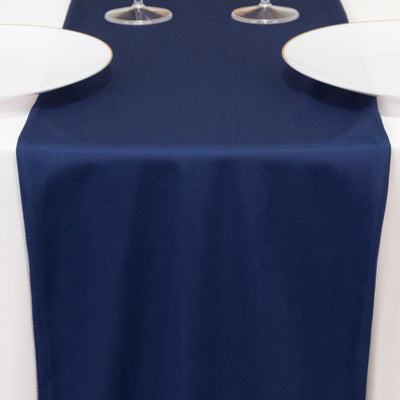 Navy table runner on a white table with two plates and glasses