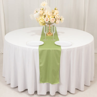 Elegant round table setup with green runner and floral centerpiece.