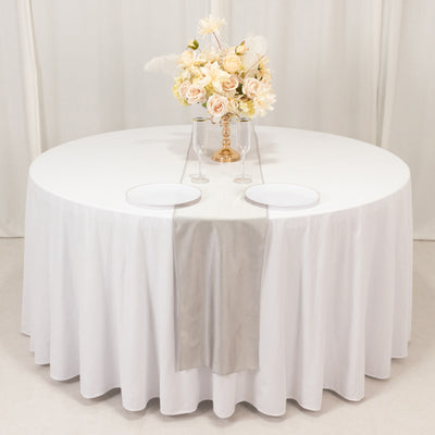 Elegant round table set with floral centerpiece and white plates.