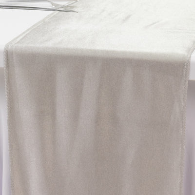 Silver velvet table runner on a white surface.