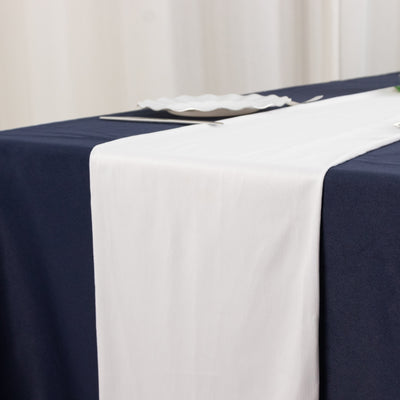 White table runner on a navy tablecloth for elegant dining decor.