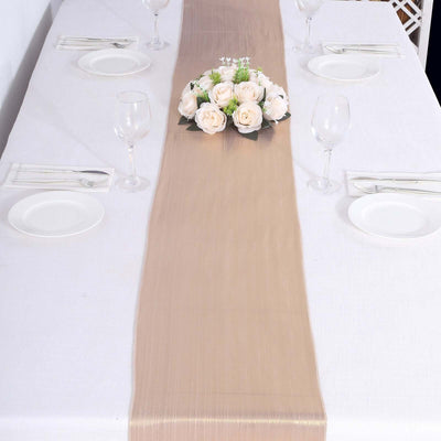 Elegant table setting with a beige runner and floral centerpiece.