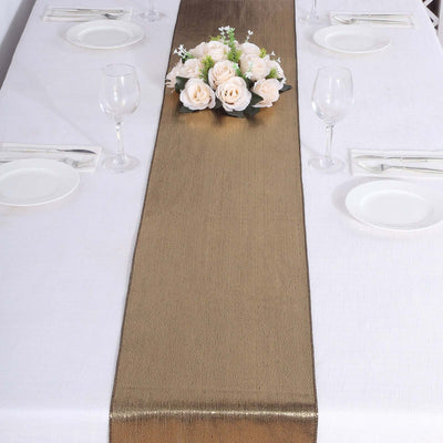 Elegant gold table runner with floral centerpiece on a dining table setting.
