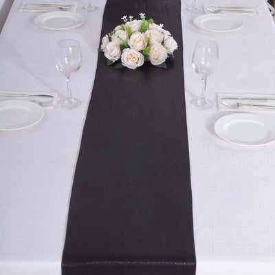 Elegant black table runner with floral centerpiece on a dining table.