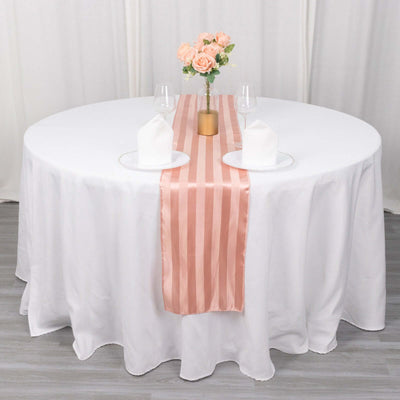 Elegant round table set with blush pink runner and floral centerpiece.