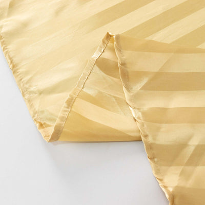 Yellow satin fabric with subtle striped pattern, elegantly draped.