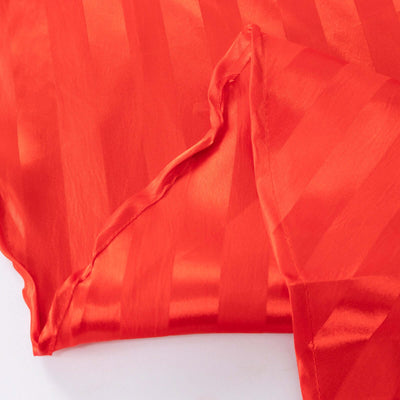 Red satin fabric with a striped pattern, showcasing its smooth texture.