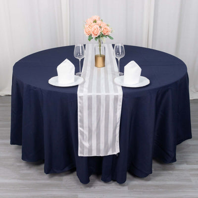 Elegant navy tablecloth with silver striped runner and floral centerpiece.