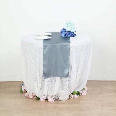 Decorative round table with lace overlay and floral accents.
