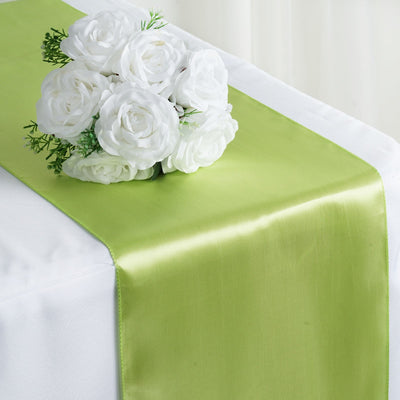 Green satin table runner with white rose bouquet on a table.