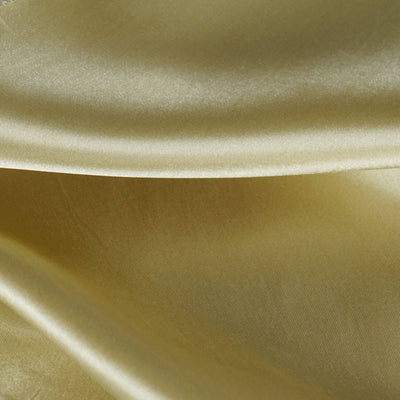 Close-up of luxurious satin fabric in soft golden hue.