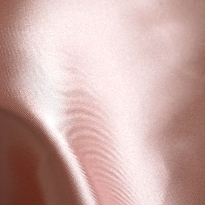 Soft pink satin fabric texture close-up.