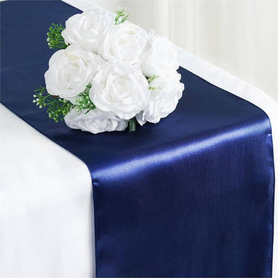 Navy satin table runner with white rose bouquet on top