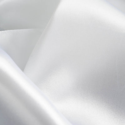 Close-up of smooth, shiny white satin fabric texture.