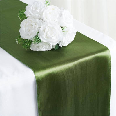 Green satin table runner with white rose bouquet arrangement.