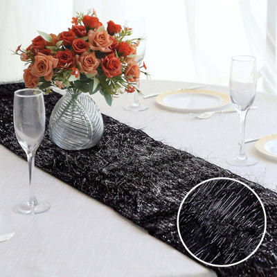 Elegant black table runner with silver accents, styled with roses and glassware.