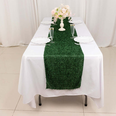 Green grass table runner on a white table setting with floral centerpiece.