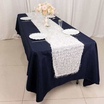 Elegant table setting with navy tablecloth and silver table runner.
