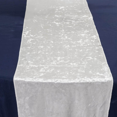 Silver velvet table runner on dark background.