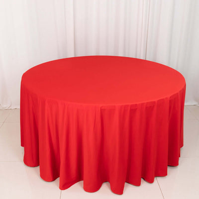 Round red tablecloth draping over a circular table.