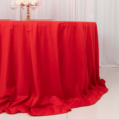 Red tablecloth draping elegantly over a round table in a bright setting.