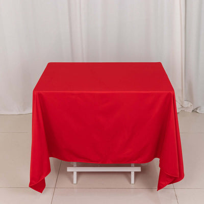 Red tablecloth draped over a table in a studio setting.
