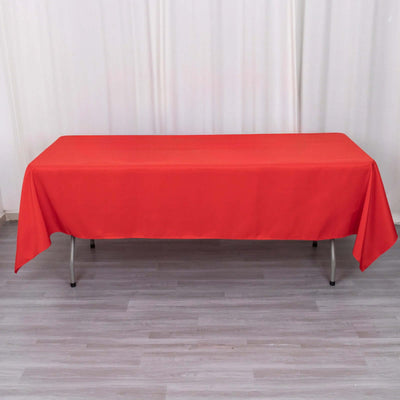 Red tablecloth on a folding table in a studio setting.