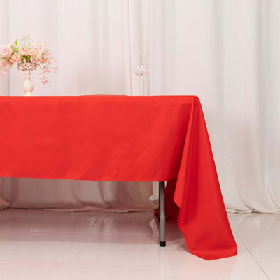 Red tablecloth draped elegantly over a table with floral arrangement