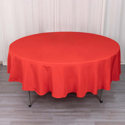 Round red tablecloth draped over a circular table.