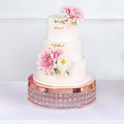Elegant three-tier wedding cake adorned with flowers and a sparkling base.
