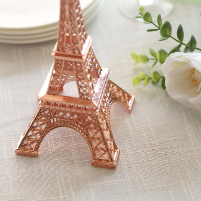 Rose gold Eiffel Tower figurine on a textured table setting.