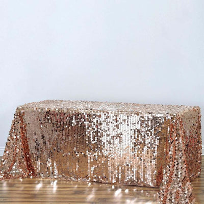 Rose gold sequined tablecloth on a plain backdrop.