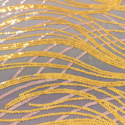 Yellow sequin fabric with wavy patterns on a gray background.