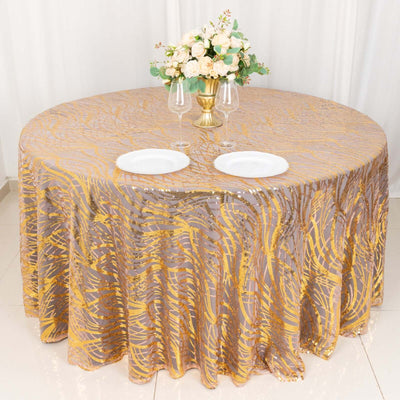 Round table with a gold and silver patterned tablecloth and floral centerpiece.