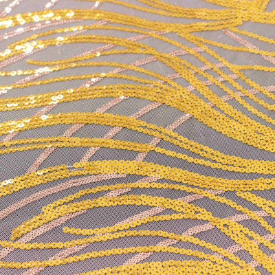Yellow sequin fabric with wavy patterns on a light background.