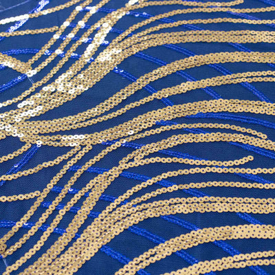 Gold and blue sequined fabric with wavy patterns.