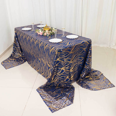 Elegant navy and gold patterned tablecloth draped over a table with decorative elements.