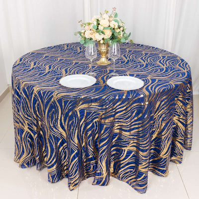 Elegant blue and gold patterned tablecloth on a round table with floral centerpiece.