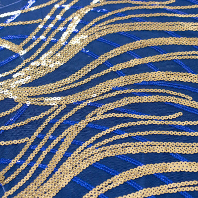 Gold and blue sequin fabric with wave patterns for fashion and craft projects.