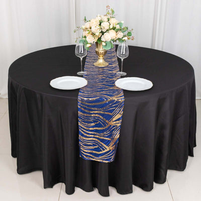 Elegant table setting with black tablecloth, floral centerpiece, and gold-accented runner.