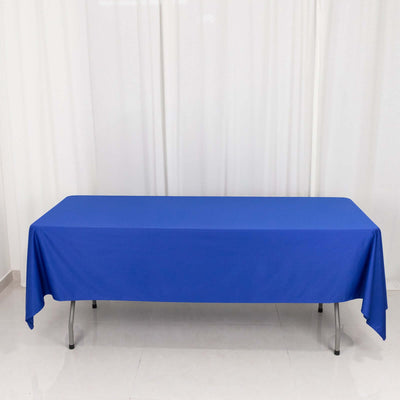 Blue tablecloth draped over a folding table on a neutral background.