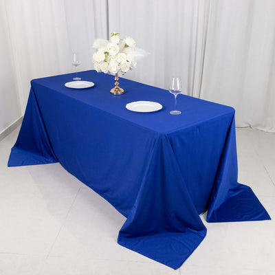 Blue tablecloth with decorative centerpiece and plates on a dining table.